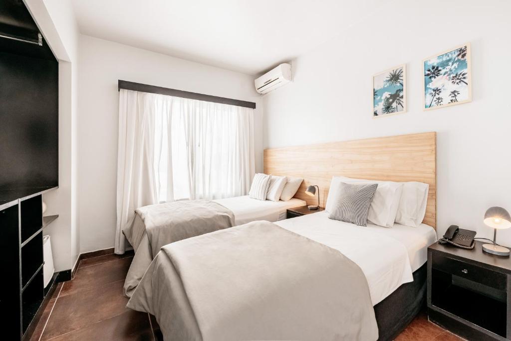 um quarto de hotel com duas camas e uma televisão em 5411 Soho Hotel em Buenos Aires