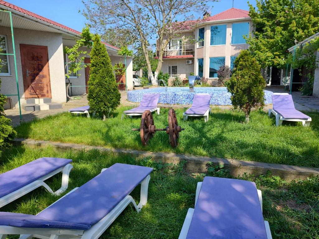 a group of purple lounge chairs in the yard of a house at ВИКЕНД in Karolino-Buhaz