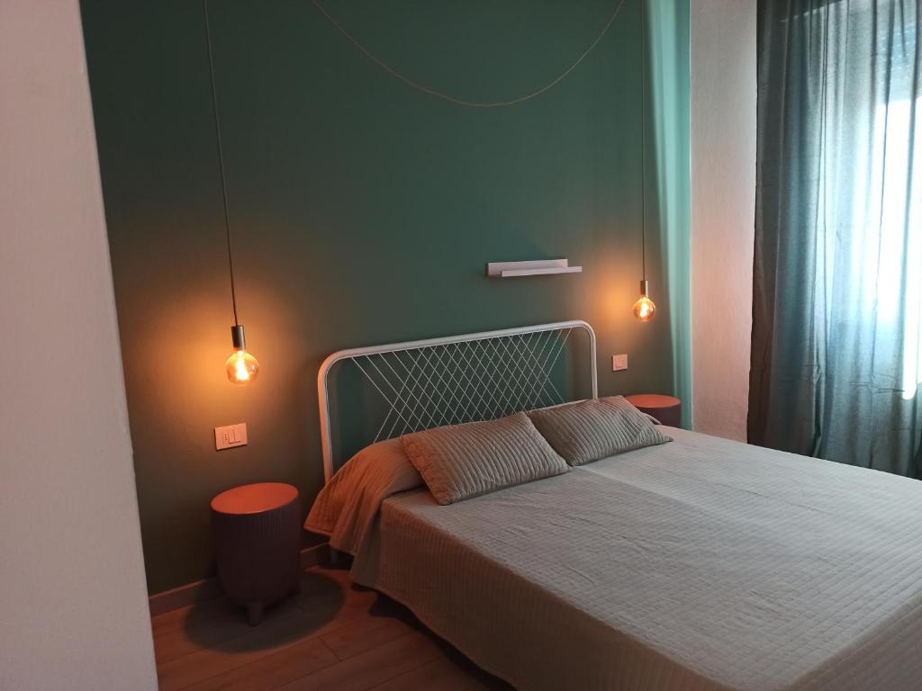 ein Schlafzimmer mit einem Bett mit zwei Leuchten in der Unterkunft BB Arcana in Follonica