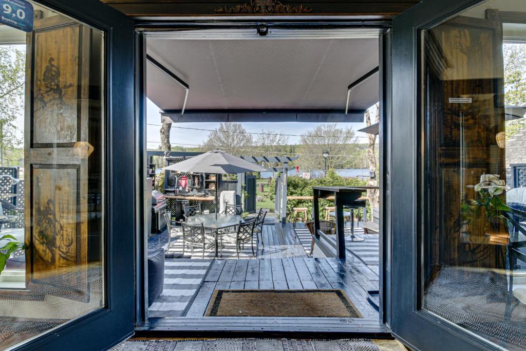 ein Fenster mit Blick auf eine Terrasse mit einem Tisch und Stühlen in der Unterkunft Gite le petit Manoir Vue sur rivière St Maurice in Grandes-Piles