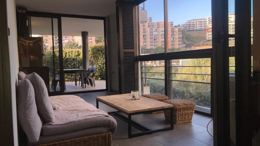 un salon avec un canapé et une table dans l'établissement T2 standing Ajaccio, à Ajaccio