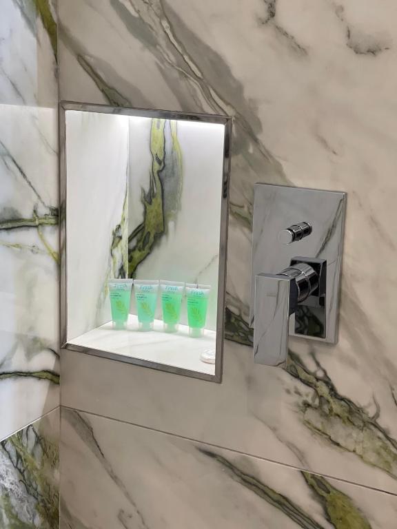 a mirror in a bathroom with three blue glasses at Vila Arial in Vlorë