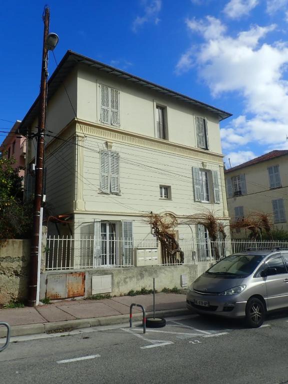 une voiture garée devant une maison blanche dans l'établissement appartement nice, à Nice