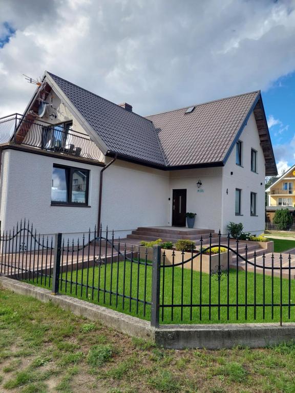 a white house with a black roof at CYKADA 4 in Ostrowo