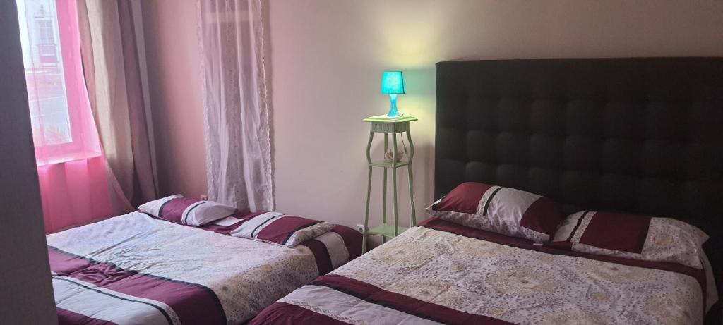 1 dormitorio con 2 camas, lámpara y ventana en Chante-Cristal, en Target