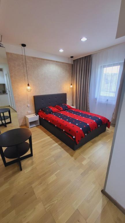 um quarto com uma cama grande e um cobertor vermelho em Garsoniera în centrul orașului vis a vis de hotel radisson em Bucareste