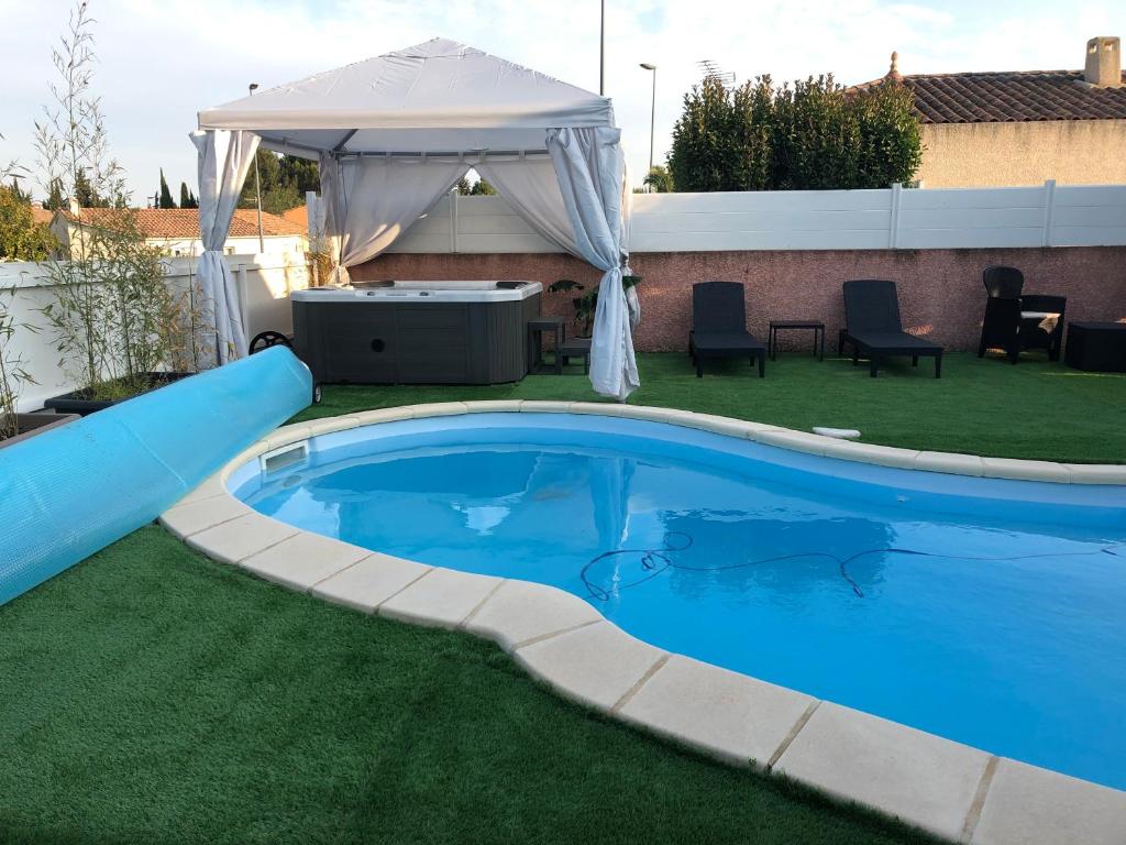 Una piscina en un patio con un cenador. en Villa Leprevost, en Béziers
