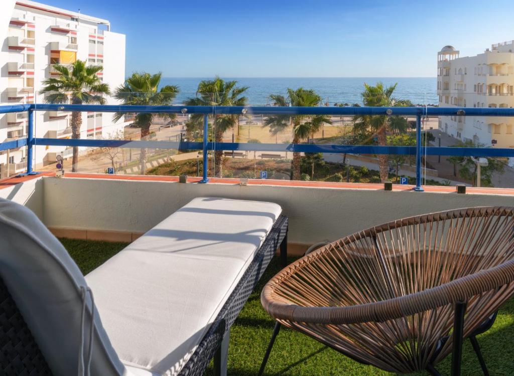 een balkon met een bank en uitzicht op de oceaan bij Apartamento Deluxe AM in Quarteira