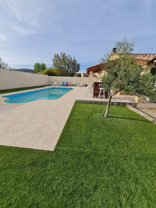 une cour avec une piscine et une pelouse dans l'établissement Appartement 53 m² - PIGNANS au coeur du var, à Pignans