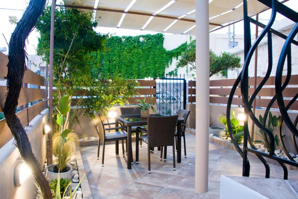 een patio met een tafel, stoelen en planten bij Sia's Sea House in Almirida