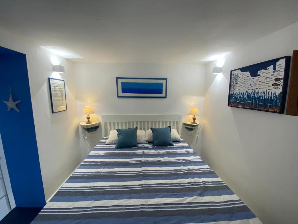 a bedroom with a bed with blue and white stripes at Casa Nadip in Ustica
