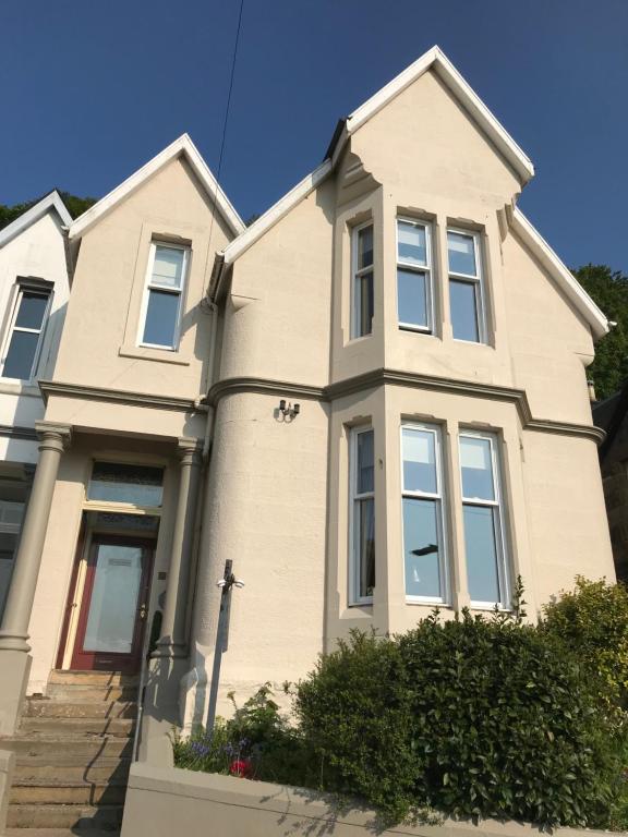 une maison blanche avec une croix devant elle dans l'établissement Blair Villa South, à Oban