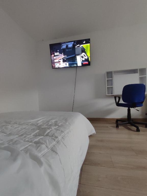 ein Schlafzimmer mit einem Bett und einem TV an der Wand in der Unterkunft Chambre privé dans une maison avec terrasse et jardin salles de bain partagées in Lille