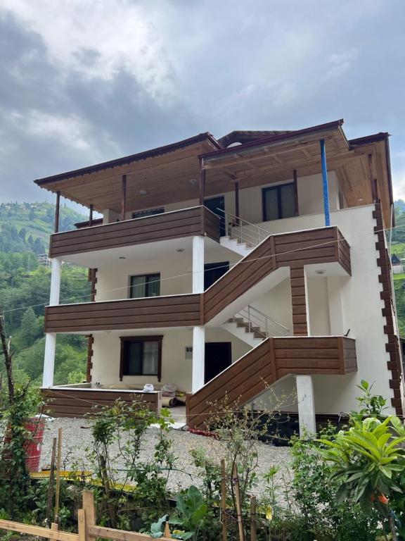 a house with wooden balconies on top of a hill at Serona Apart & Bungalow in Çamlıhemşin