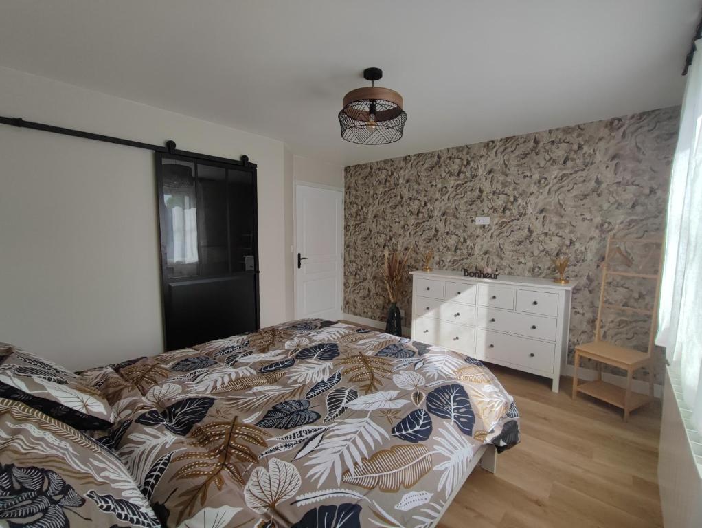 - une chambre avec un lit et une commode dans l'établissement Le Gîte de Daisy, à Saint-Côme-du-Mont