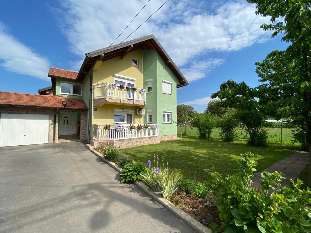 a green and yellow house with a driveway at Villa Emina in Sarajevo