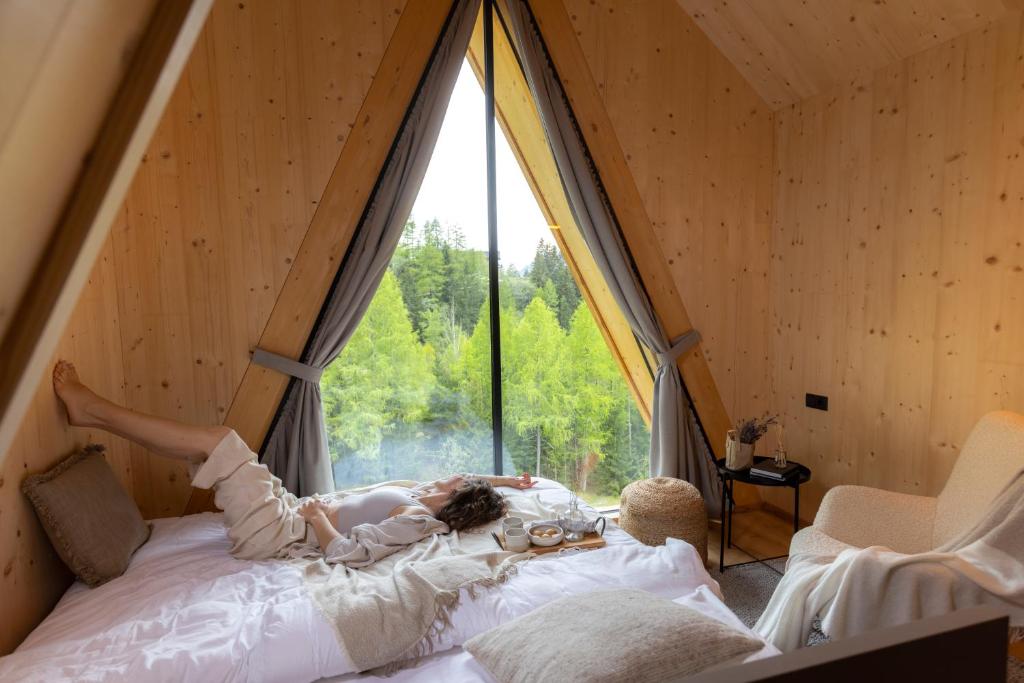 a child laying on a bed in a room with a window at Collis Hill in Kals am Großglockner