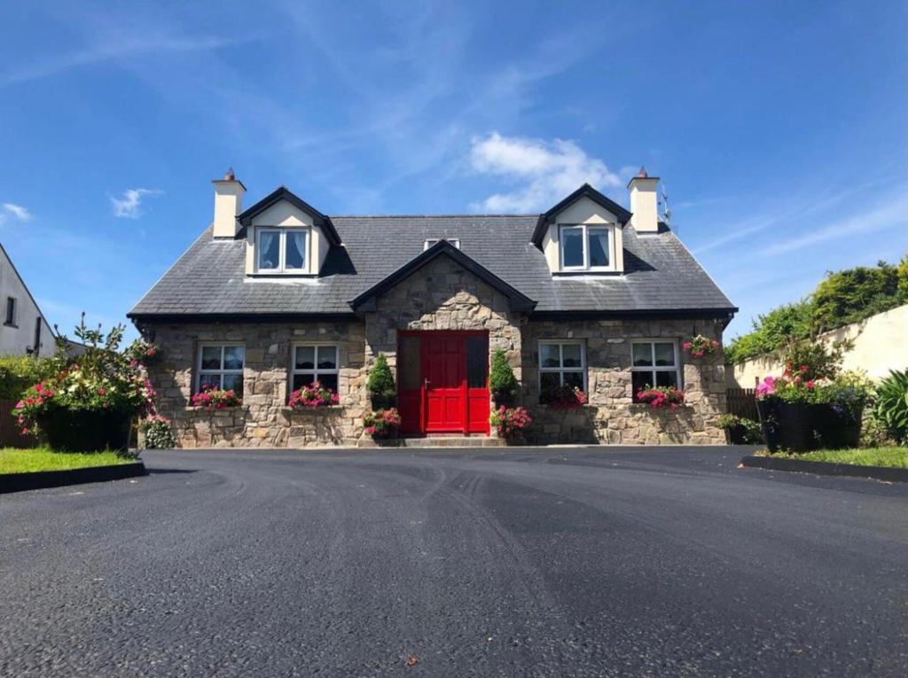 a house with a red door on a street at Cosy Rooms in a Stone Cottage in Galway