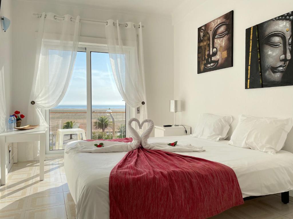 a bedroom with a large white bed with a large window at Stella di Mare - Alojamento Local in Figueira da Foz