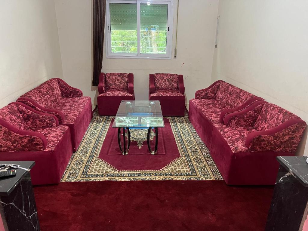 イモーザル・ドゥ・カンダルにあるDar Diafa-Imouzzer Kandarのリビングルーム(赤いソファ3台、テーブル付)