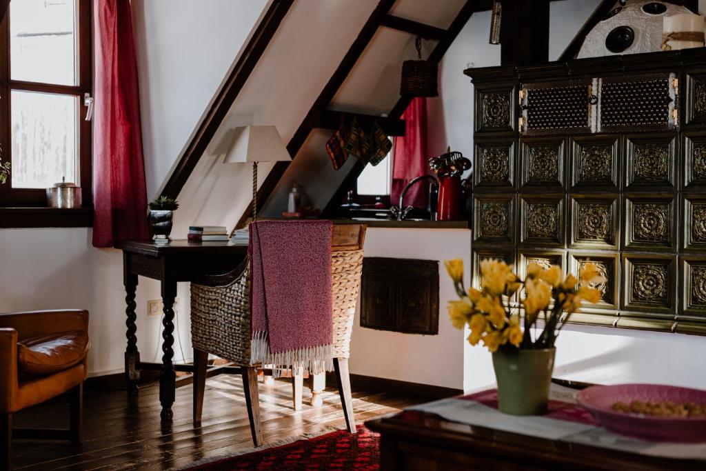 a living room with a desk and a table with flowers at Jagdhaus in der Rhön in völliger Alleinlage in Gersfeld