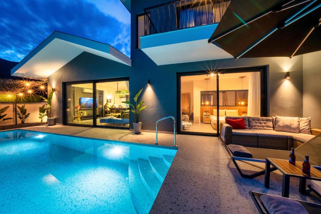 uma casa com piscina e sala de estar em Villa Oxy Private Pools & Seaview & Heated Indoor Pool em Göcek