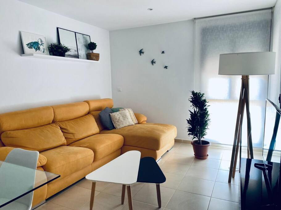 a living room with a brown couch and a table at Apartamento Pàmpol in Lliber
