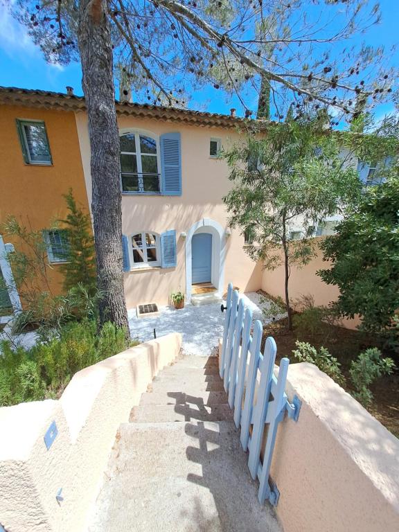 una casa con una recinzione bianca davanti di La villa Charles Grimaud Les Restanques Golf de Saint Tropez a Grimaud