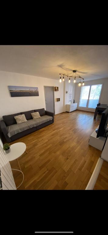 un grand salon avec un canapé et une table dans l'établissement T3 collines niçoises au calme avec stationnement privatif, à Nice