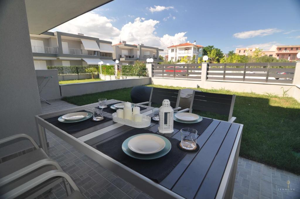 a table with plates on it on a patio at Zennova #24, FLOW Nikiti Family Apt in Nikiti