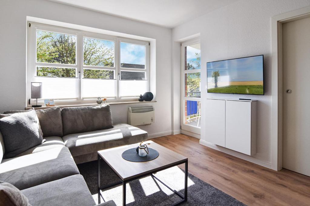 a living room with a couch and a flat screen tv at Baltic Suite 16 in Stakendorfer Strand