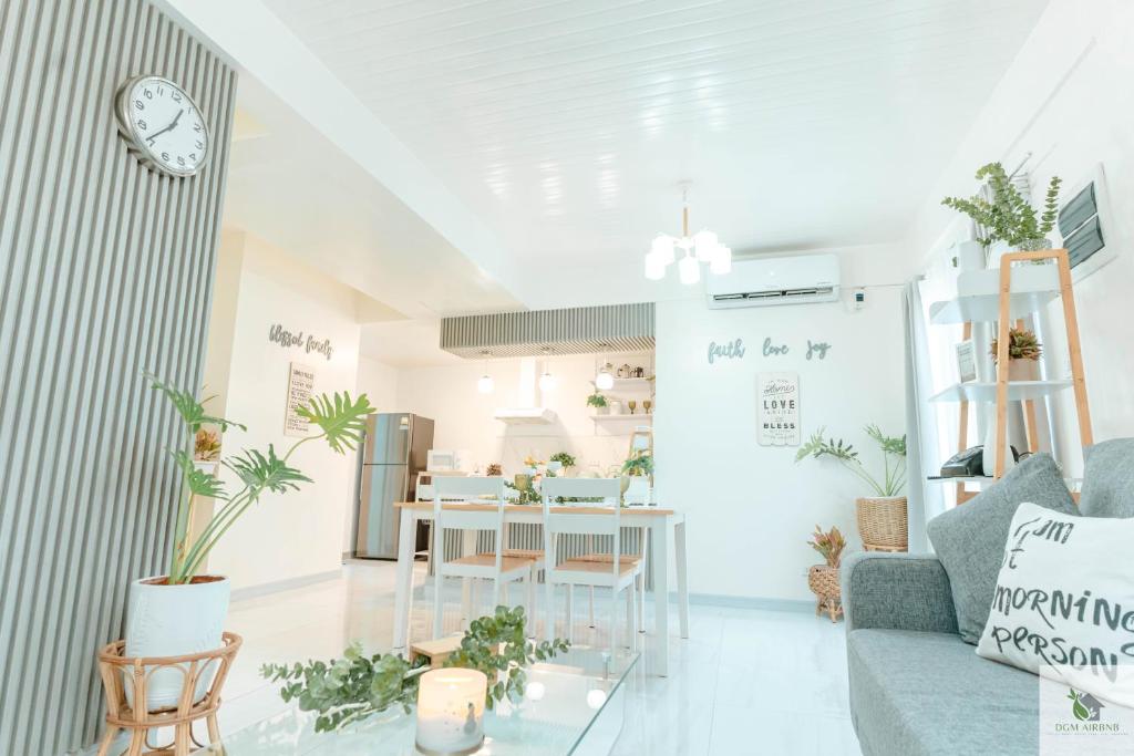 DGM AirBnB Urdaneta Pangasinan : غرفة معيشة مع أريكة وطاولة بالنباتات