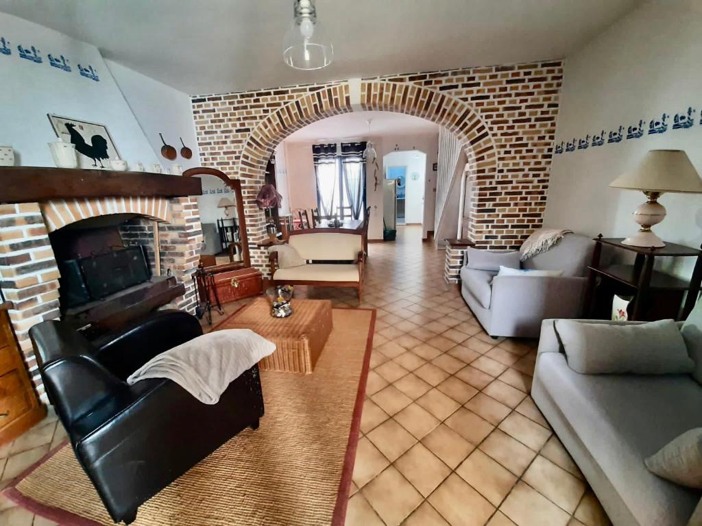 un salon avec un canapé et un mur de briques dans l'établissement Maison de pêcheur classée 3 étoiles, à Saint-Valery-sur-Somme