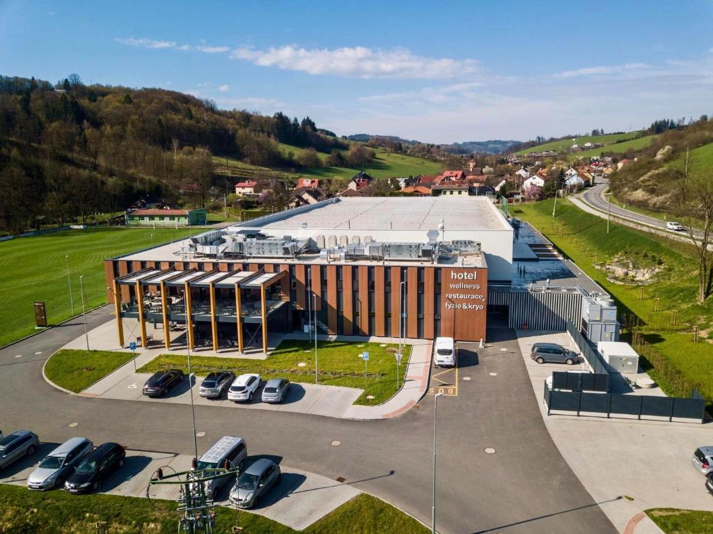 un grand bâtiment avec des voitures garées dans un parking dans l'établissement Kapka resort, à Vsetín