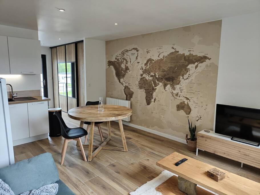 soggiorno con tavolo e mappa sul muro di Studio neuf proche centre-ville a Pabu