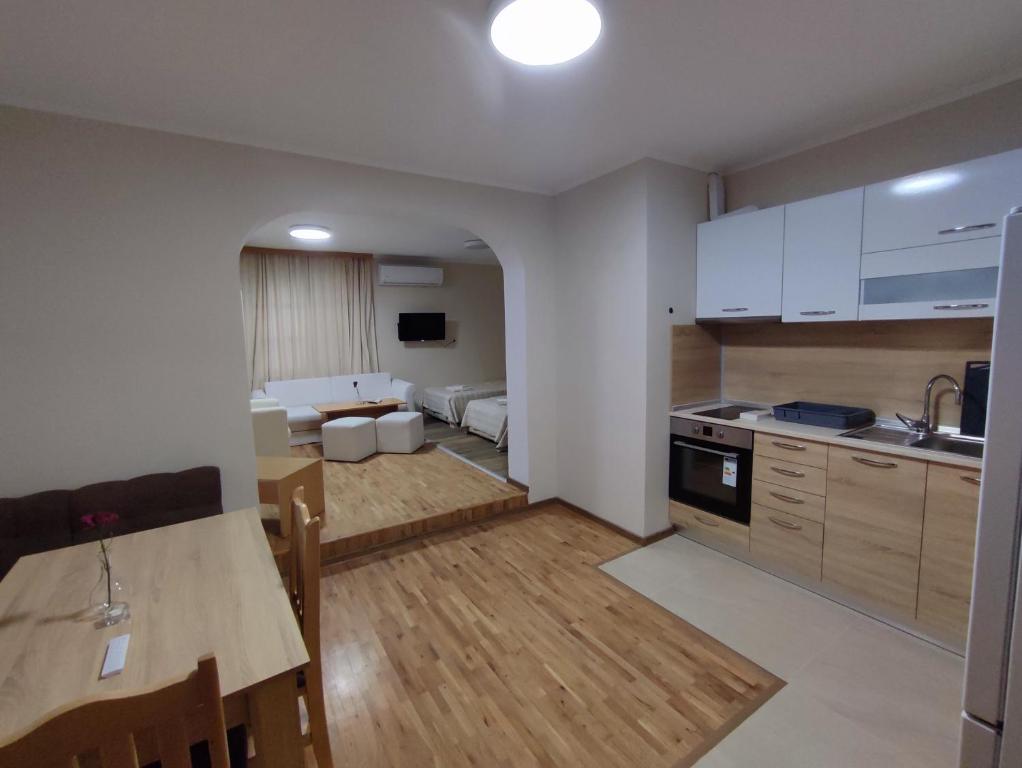 uma cozinha e sala de estar com uma mesa e uma cozinha e um sofá em Longoz em Bliznatsi