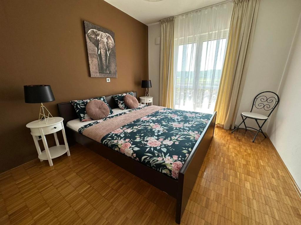 - une chambre avec un lit et une fenêtre avec un éléphant dans l'établissement Apartma Zonta, à Sečovlje