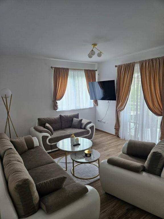 a living room with two couches and a table at Golden Sky in Cazin