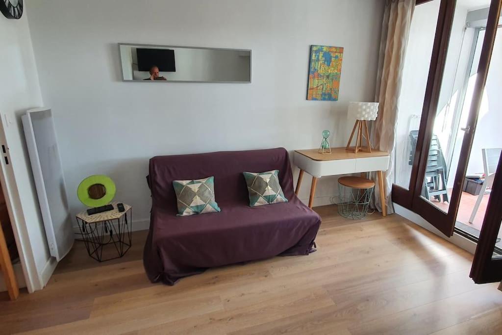 sala de estar con sofá púrpura y mesa en Studio cabine en bord de mer, à La Grande-Motte en La Grande-Motte