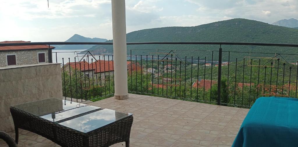 balkon ze stołem i widokiem na wodę w obiekcie Lustica-Apartment Dora3 w mieście Herceg Novi