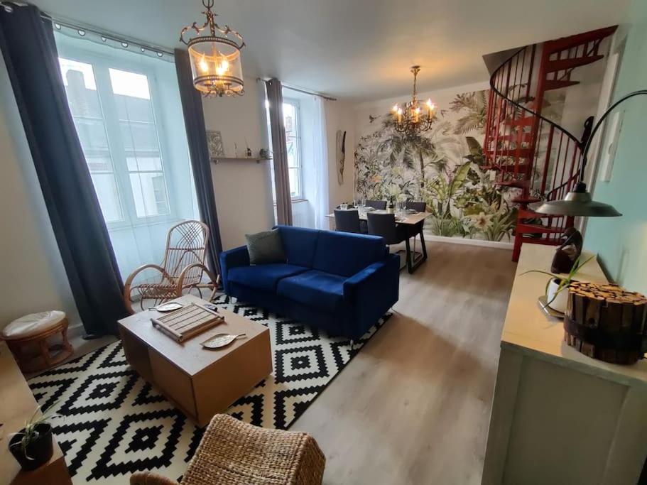 sala de estar con sofá azul y mesa en Le TROPICA Appartement 2 chambres, plein Sud centre ville de VITRÉ en Vitré