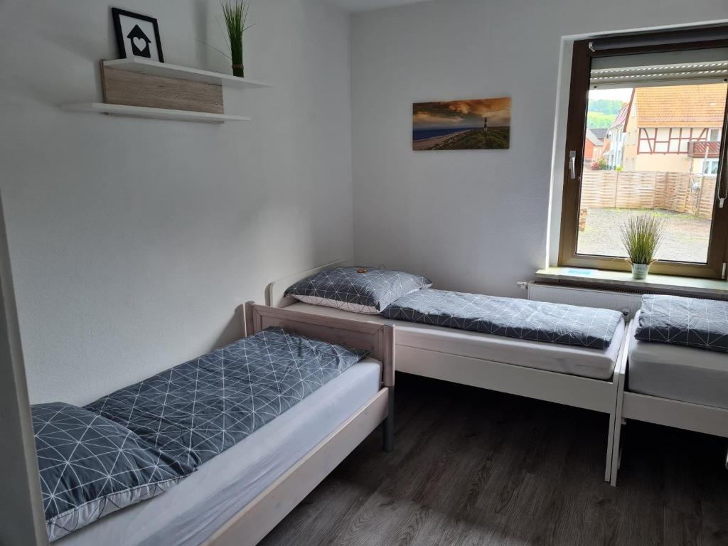 2 Betten in einem Zimmer mit Fenster in der Unterkunft Monteuroase mit 2 Schlafzimmern in Melsungen - Schwarzenberg MwSt ausweisbar in Melsungen
