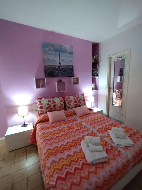 una camera da letto con un grande letto con due asciugamani di INTERO APPARTAMENTO catania policlinico a Gravina di Catania