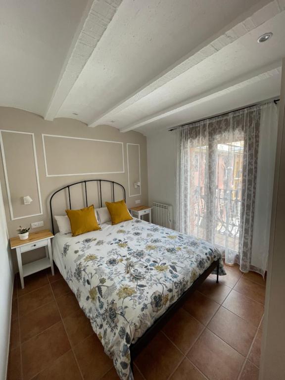 a bedroom with a bed with yellow pillows and a window at Apartamento vacacional in El Pont de Suert