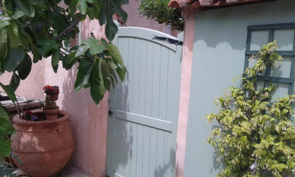 une porte blanche d'une maison avec une plante en pot dans l'établissement La Figounette du soleil, à Le Revest-le-Eaux