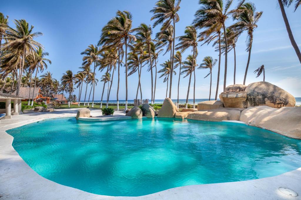 - une piscine avec des palmiers dans un complexe dans l'établissement Villas San Vicente, à Acapulco
