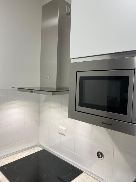 a kitchen with a microwave oven and white tiles at Casa Valentina 1 in Perugia