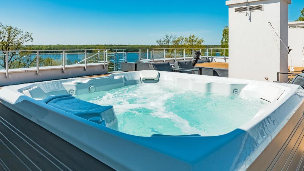a hot tub on the deck of a house at Apartamenty Stranda Residence nad jeziorem Mazury Holiday in Giżycko