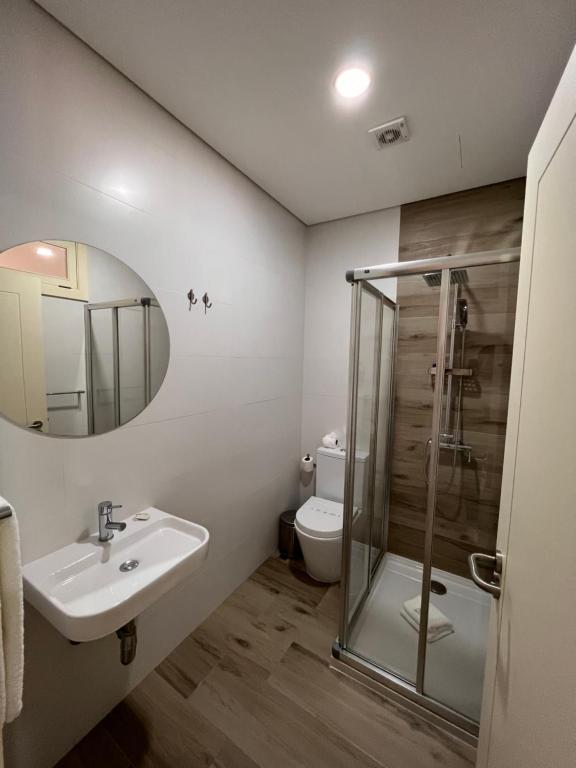 a bathroom with a sink and a toilet and a mirror at Pátio 29 - Guest House in Viana do Castelo