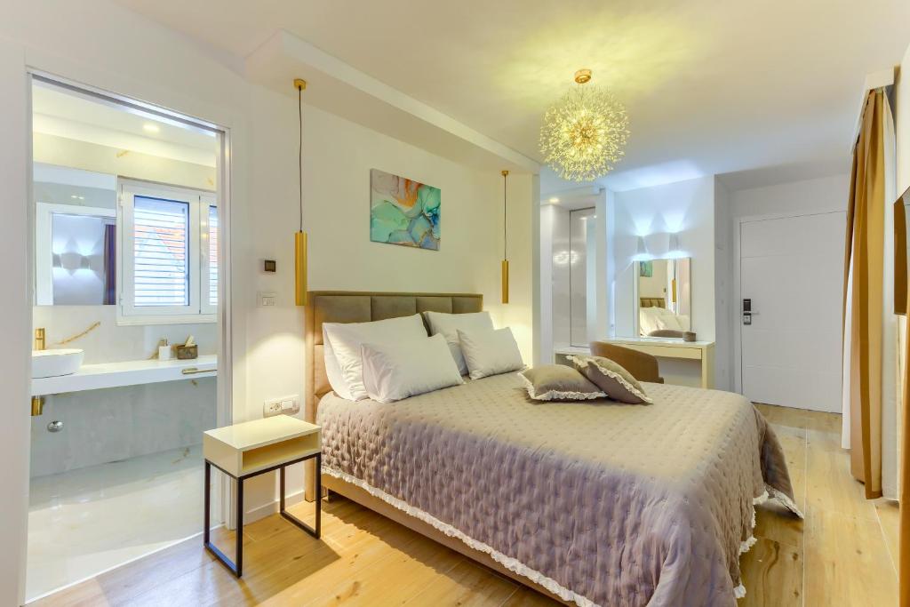 a bedroom with a large bed and a bathroom at Irini Luxury Rooms in Split